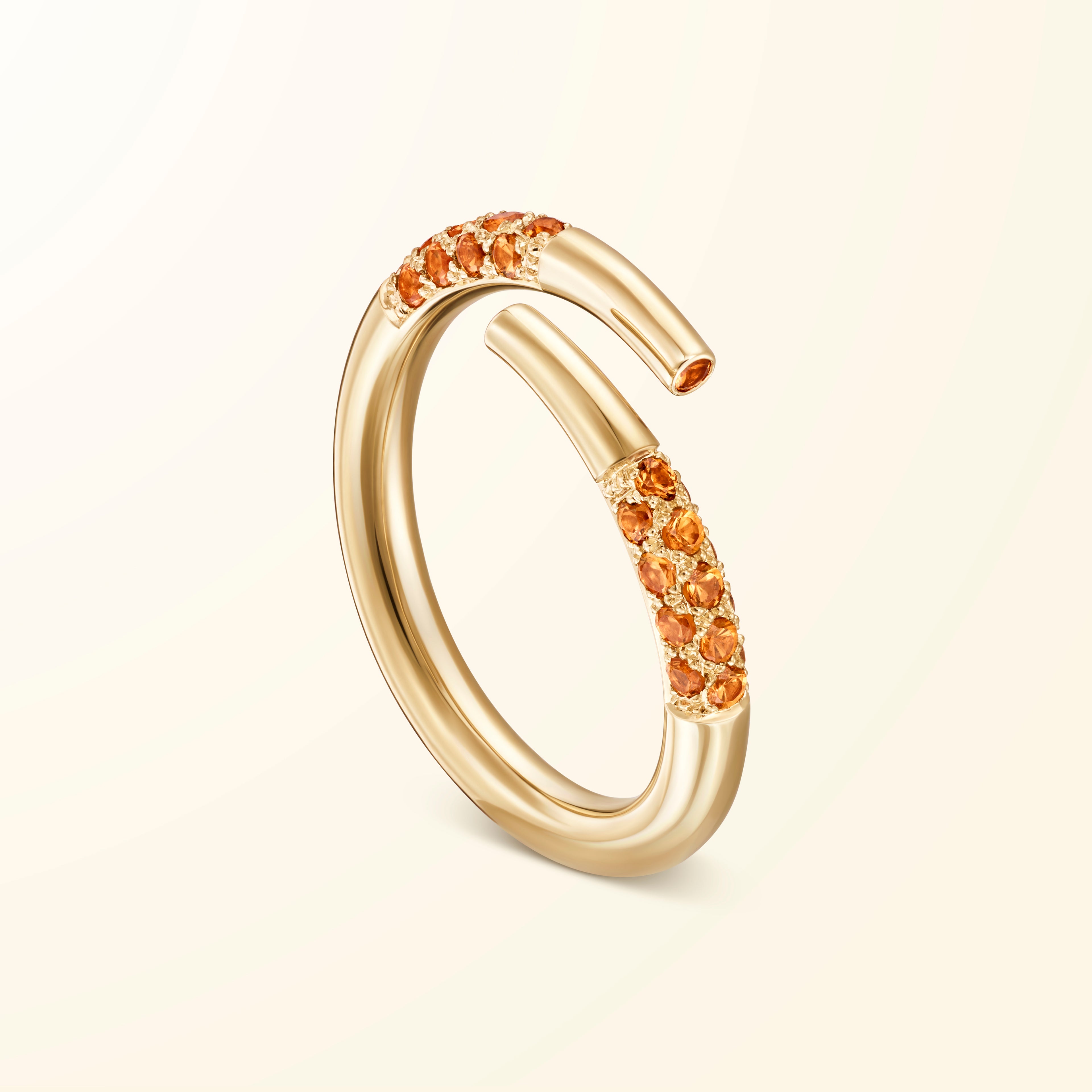 Bague bypass en or jaune 18 carats sertie de grenats spessartites évoquant un bâtonnet de jeu de mikado recourbé