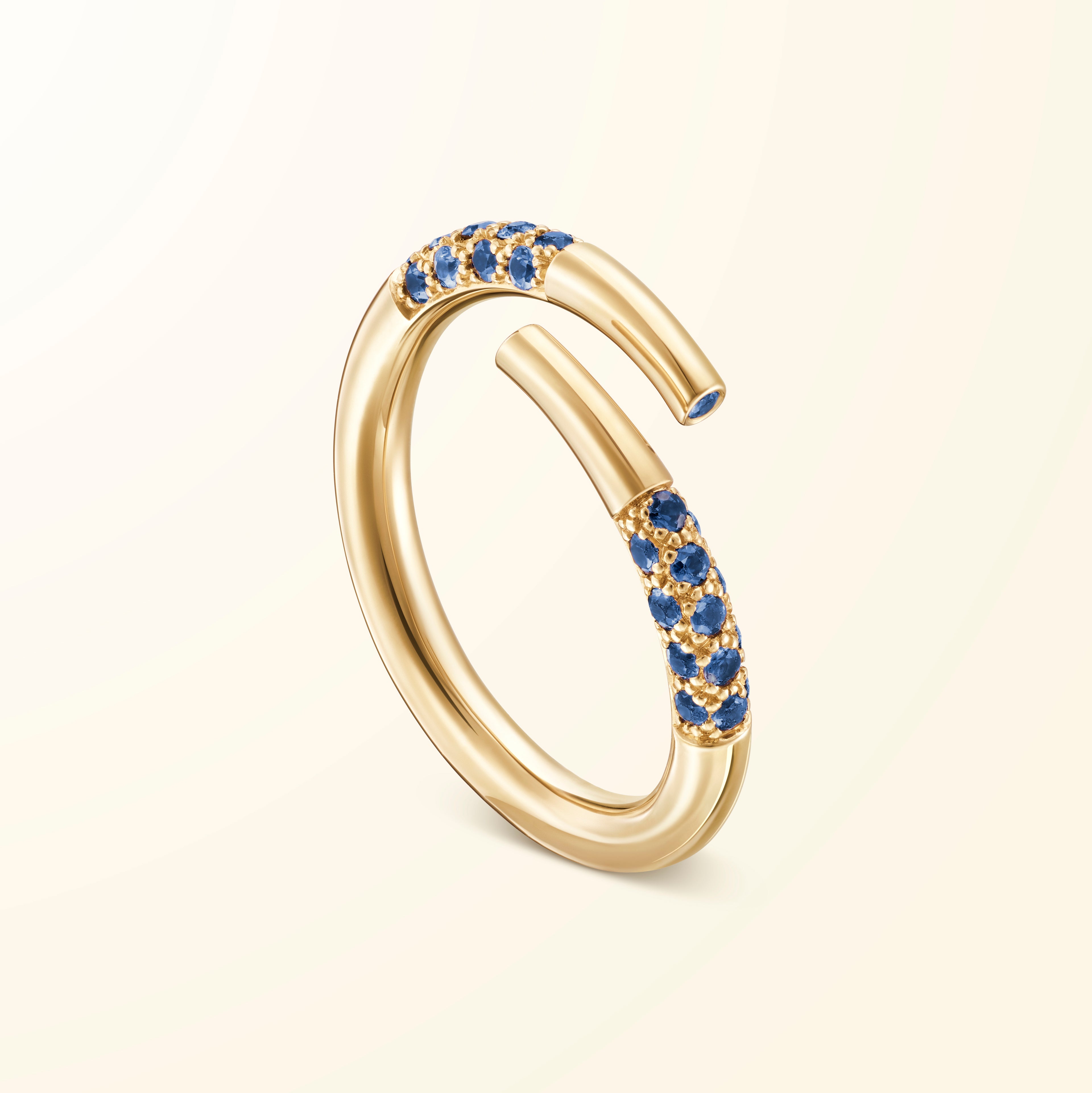 Bague bypass en or jaune 18 carats sertie de saphirs bleus évoquant un bâtonnet de jeu de mikado recourbé