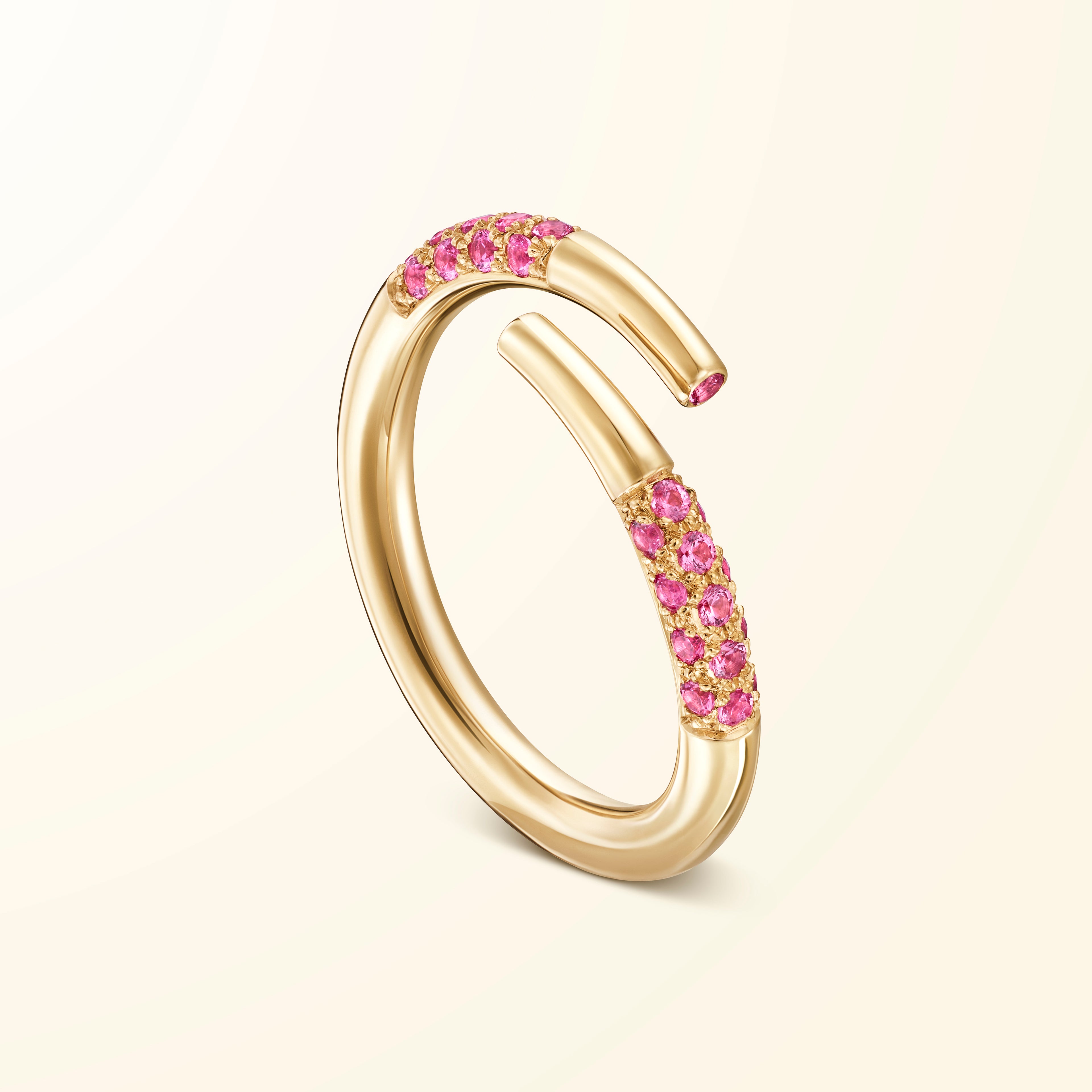 Bague bypass en or jaune 18 carats sertie de spinelles roses évoquant un bâtonnet de jeu de mikado recourbé
