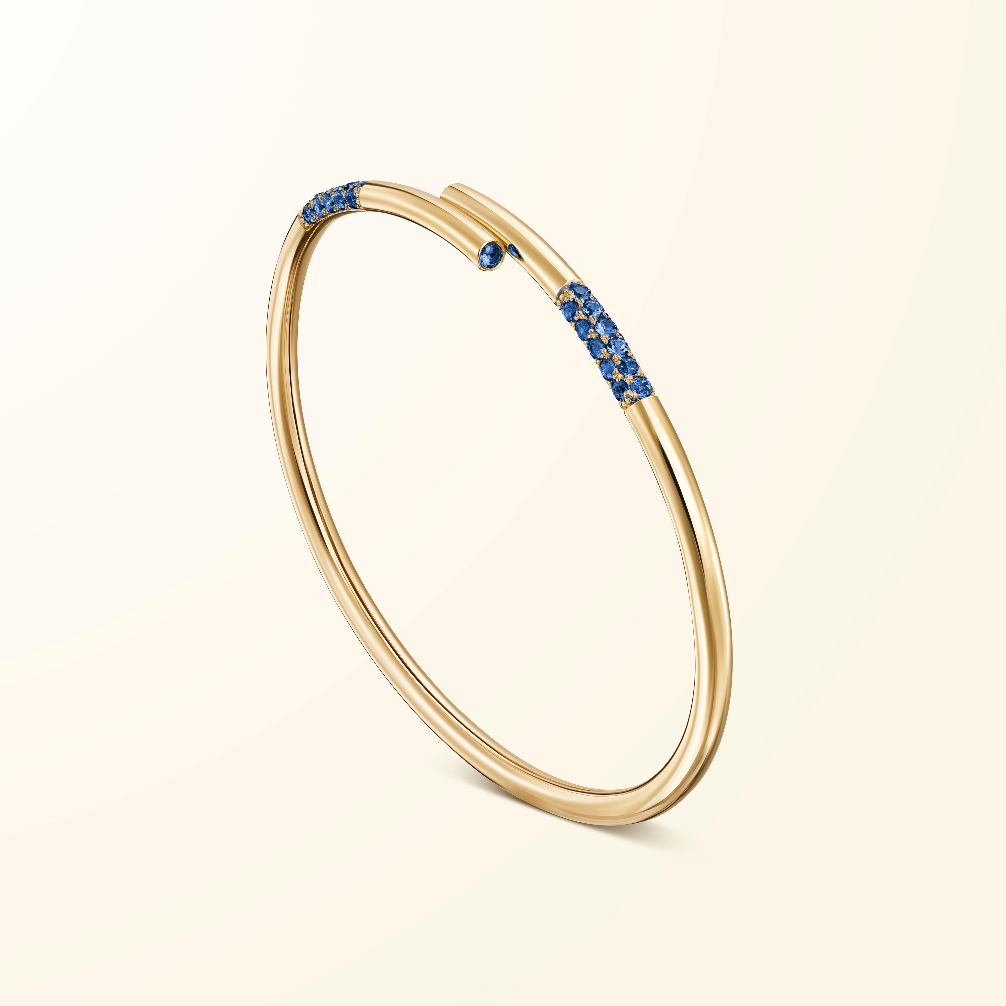 Bracelet en or jaune 18 carats serti de saphirs bleus évoquant un bâtonnet de jeu de mikado recourbé